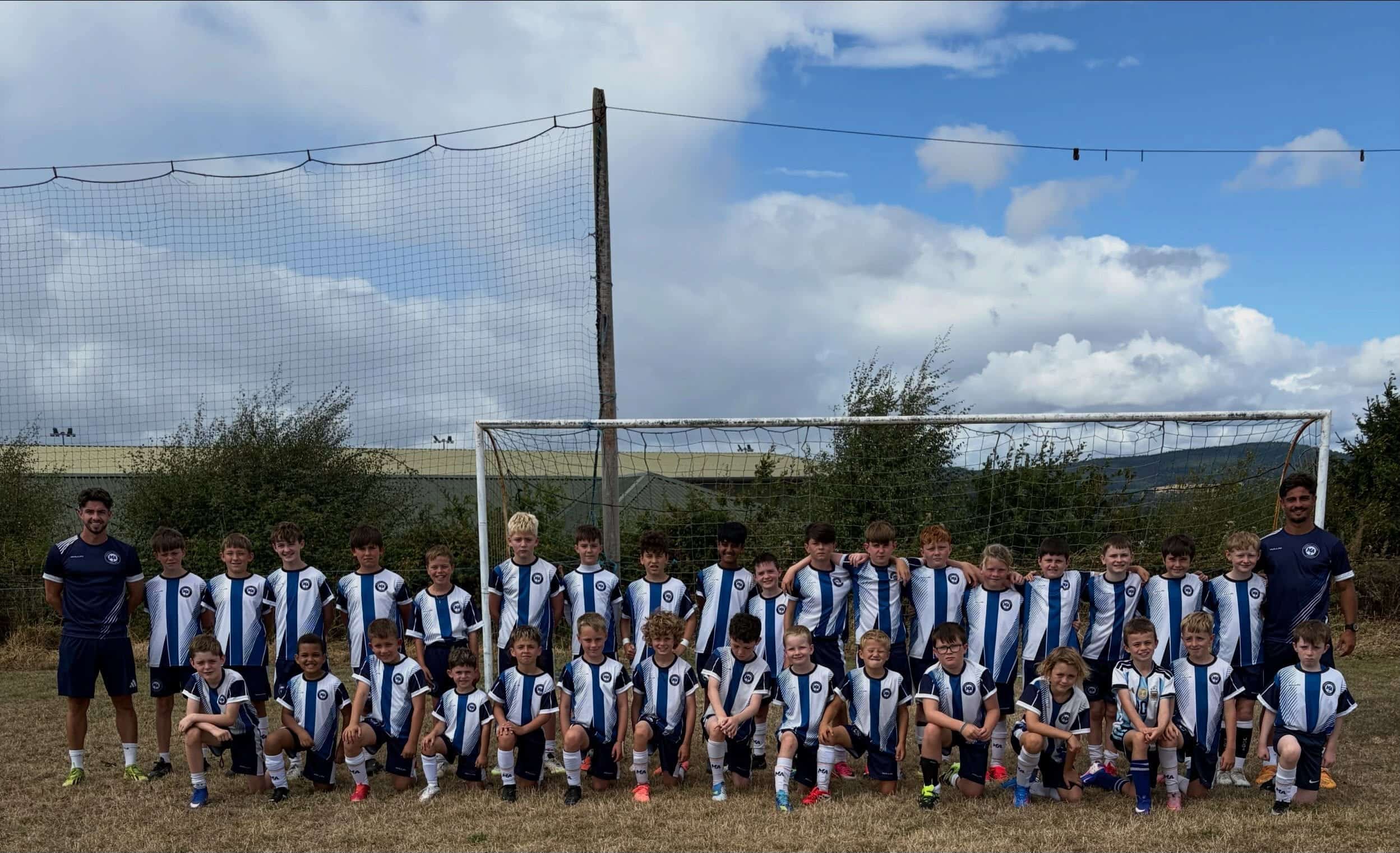 The full M&A Football Academy squad with coaches on either side