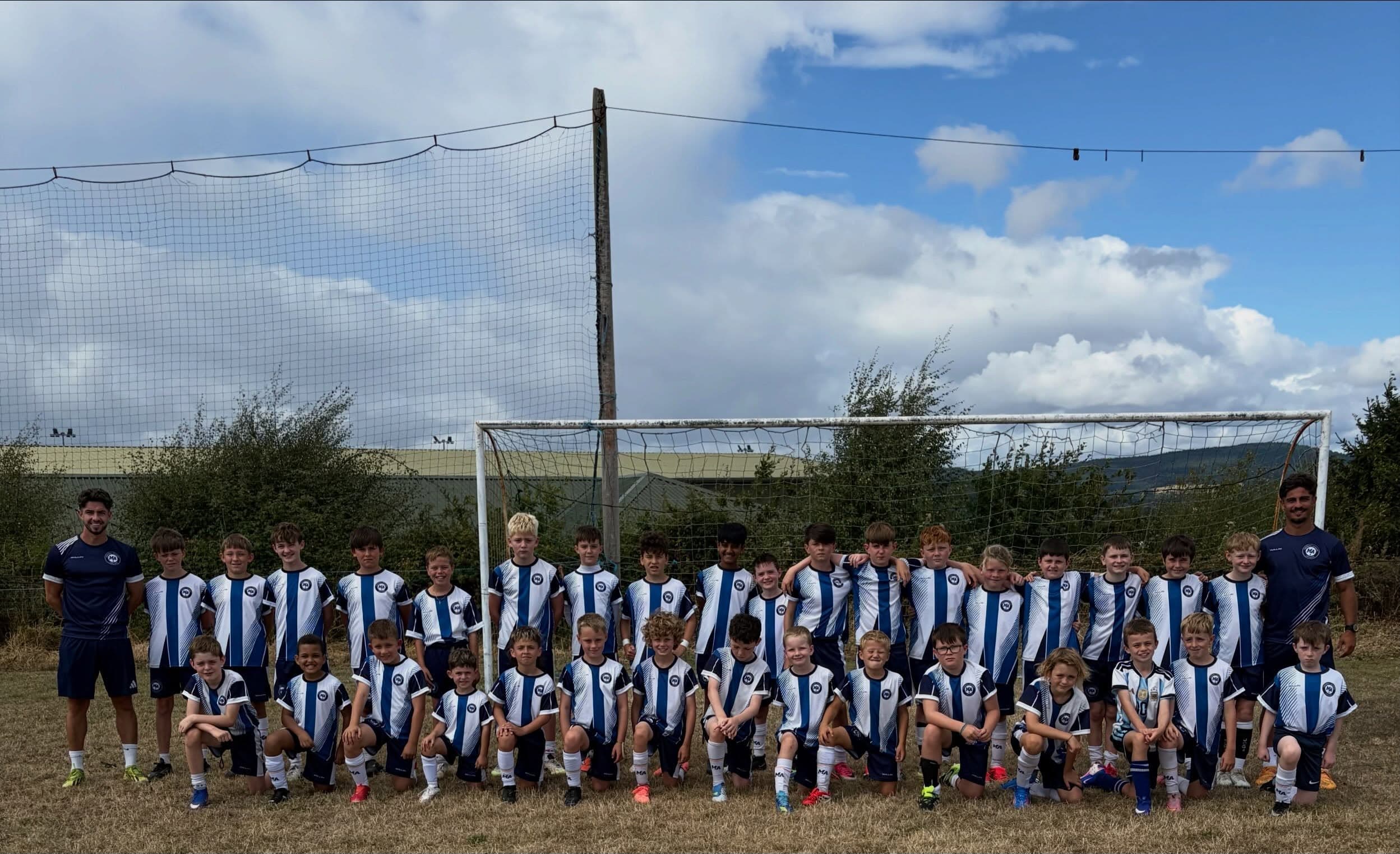 The full M&A Football Academy squad with coaches on either side