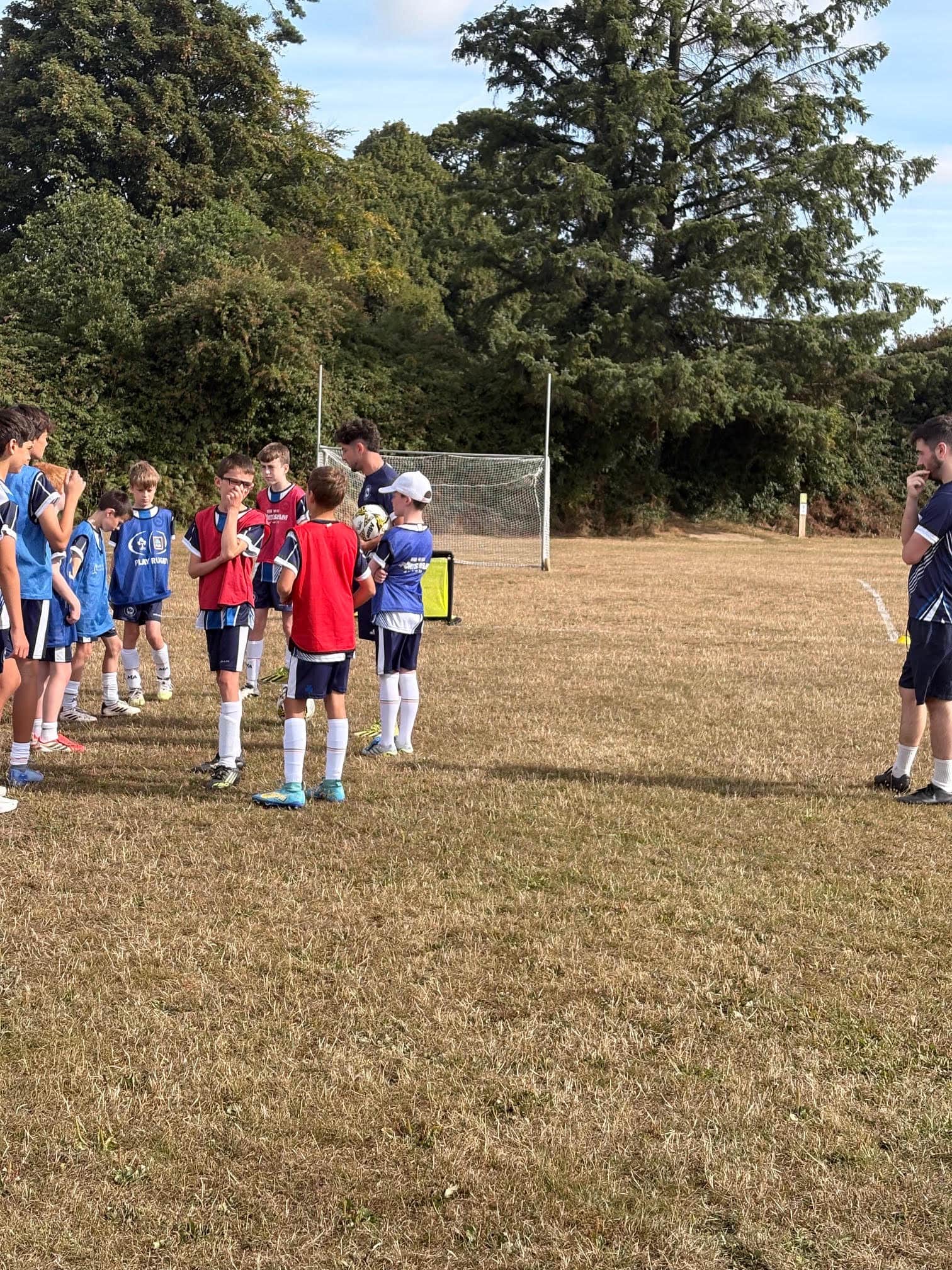 Small-group football camp training session in bibs